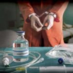 Execution Chaos Shocks Tennessee Medical vials and IV lines on a table with a handcuffed person in the background