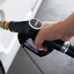 Trump Bets on Russian Diesel A hand holding a diesel fuel nozzle while refueling a vehicle